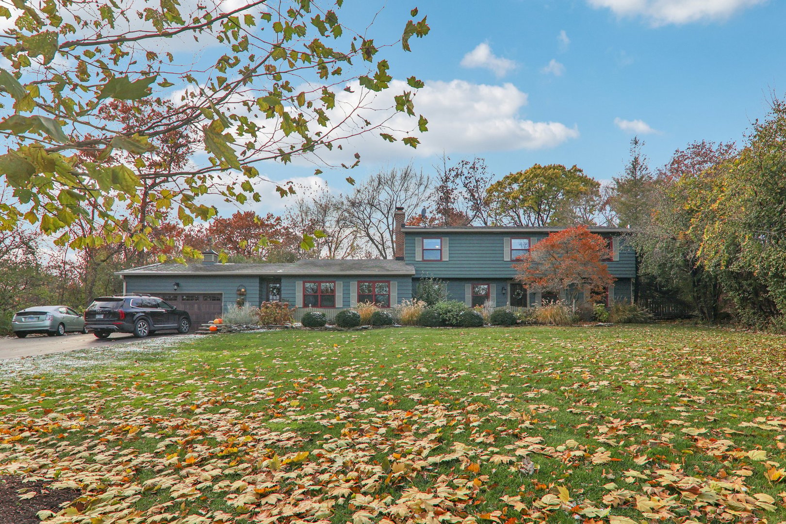 a view of a house with a big yard and large trees