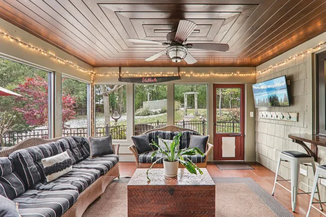 a living room with furniture a wooden floor and a large window