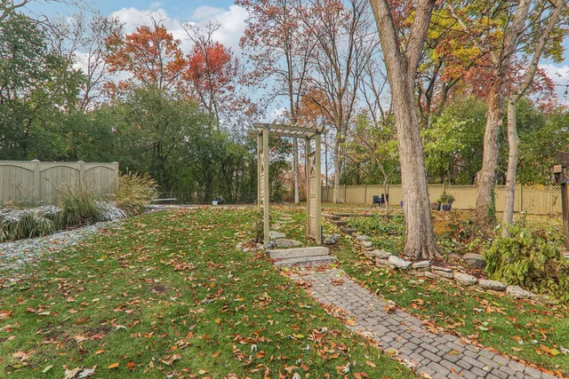 a view of a chair and table in backyard of the house