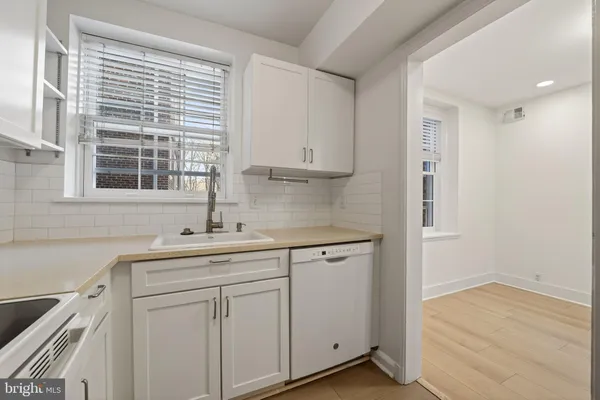 a kitchen with white cabinets sink and white appliances