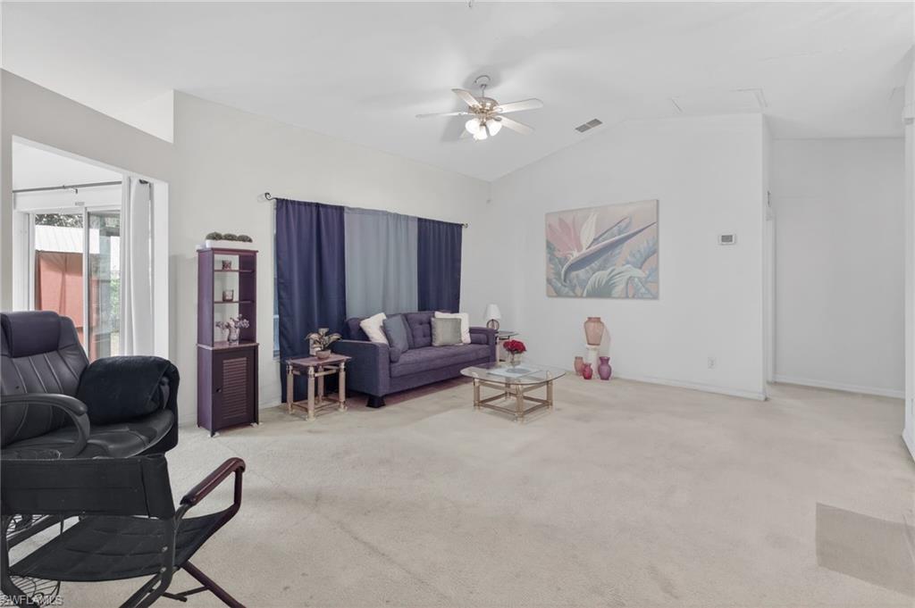 3920 10th Street North Naples, FL 34103 - Photo 13 of 47 Living room featuring light carpet, ceiling fan, and lofted ceiling