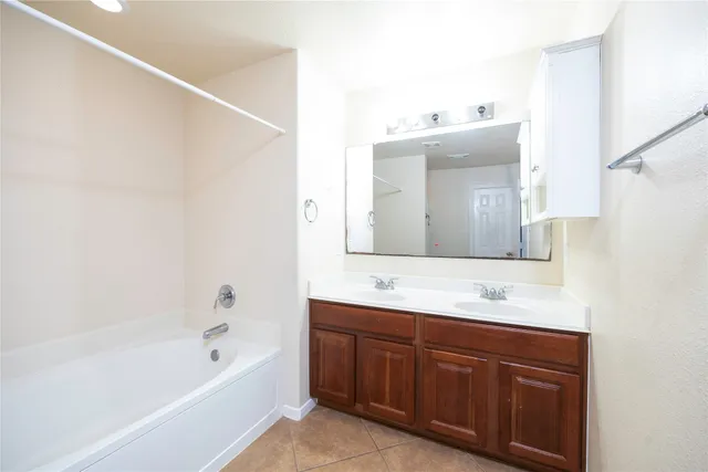 a bathroom with a tub sink and mirror