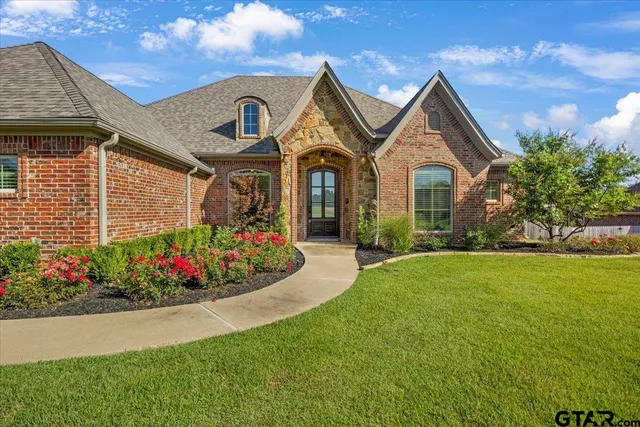 a front view of a house with a garden