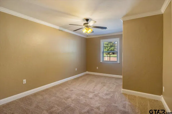 an empty room with a ceiling fan and a window