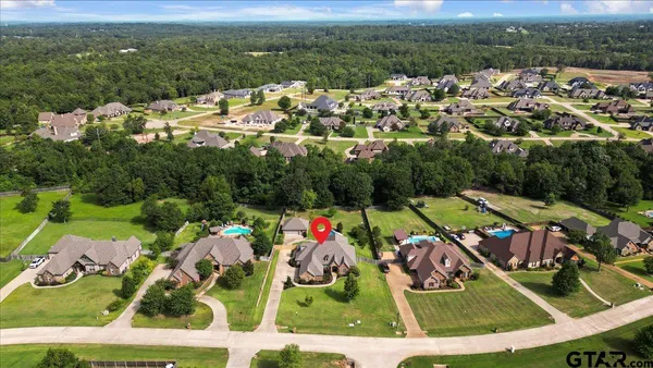 an aerial view of residential house with outdoor space and trees