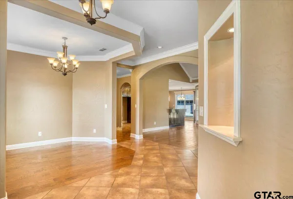 a view of a hallway with wooden floor and chandelier