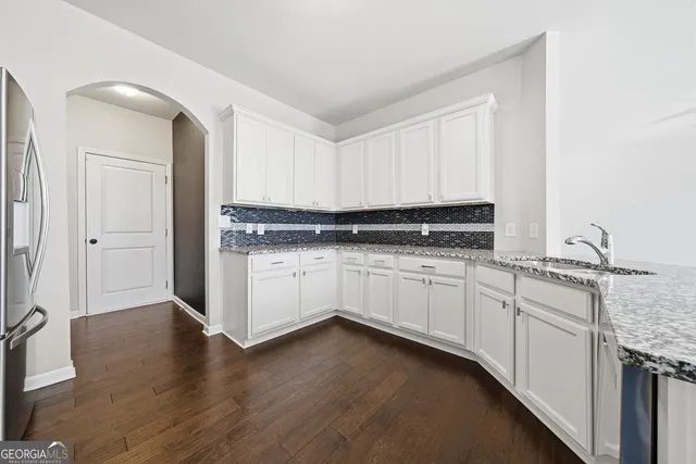 a kitchen with granite countertop white cabinets and white appliances