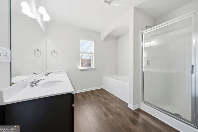 a bathroom with a double vanity sink a mirror and a shower