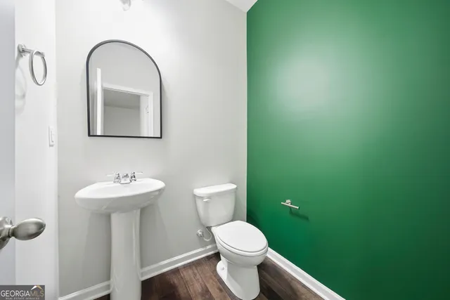 a bathroom with a toilet sink and mirror
