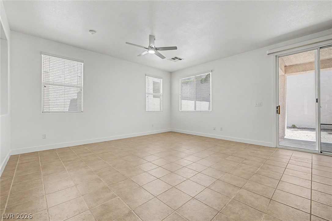 835 Entrada Ridge Avenue Henderson, NV 89012 - Photo 6 of 34 A well-lit living area features tiled flooring and convenient patio access.