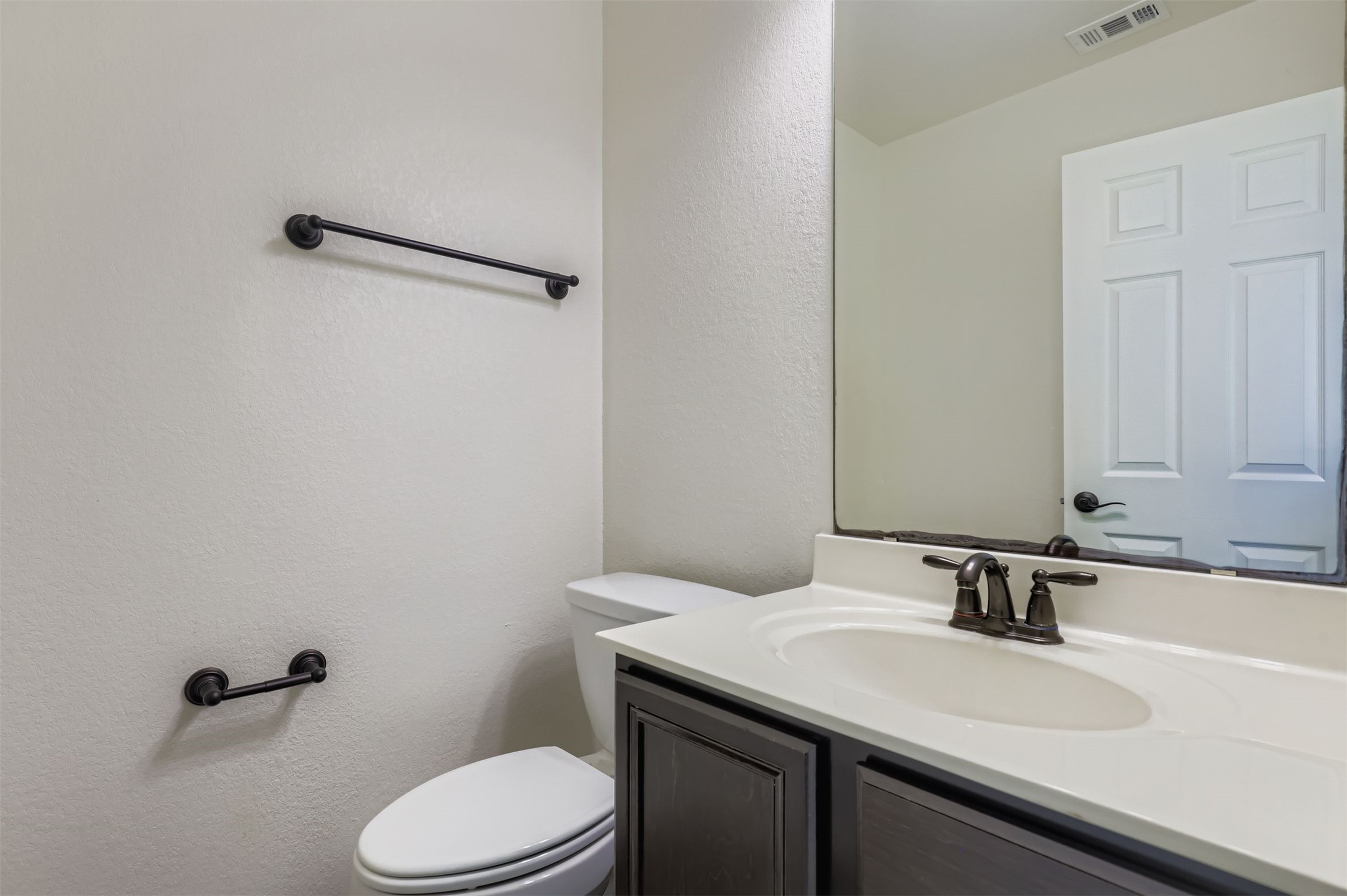18808 Star Gazer Way Pflugerville, TX 78660 - Photo 21 of 27 Half bathroom with a textured wall and vanity