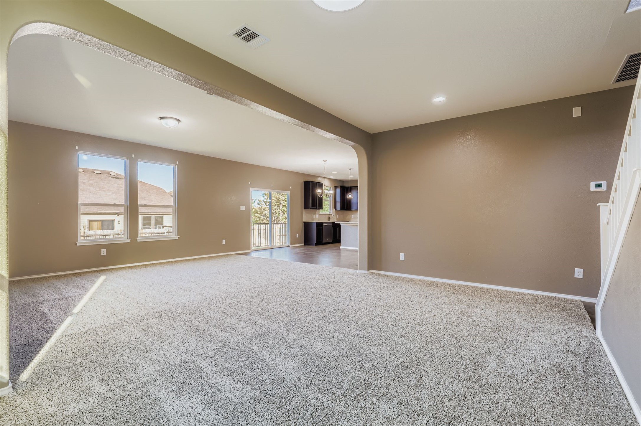18808 Star Gazer Way Pflugerville, TX 78660 - Photo 9 of 27 Unfurnished living room featuring carpet flooring and arched walkways