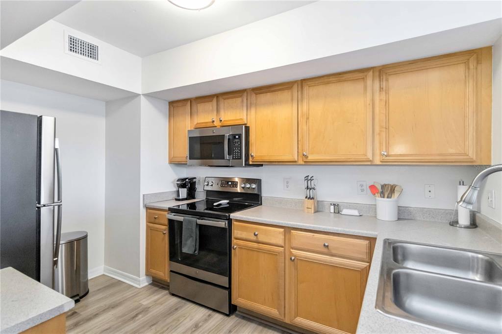 1050 Villagio Circle, Unit 206 Sarasota, FL 34237 - Photo 16 of 57 a kitchen with a sink a stove and cabinets