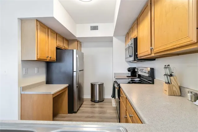 a kitchen with stainless steel appliances granite countertop a sink a stove and a refrigerator