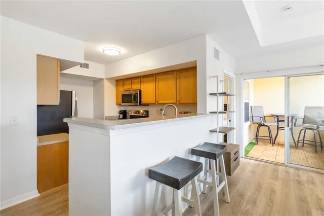 a living room with furniture a large window with kitchen view