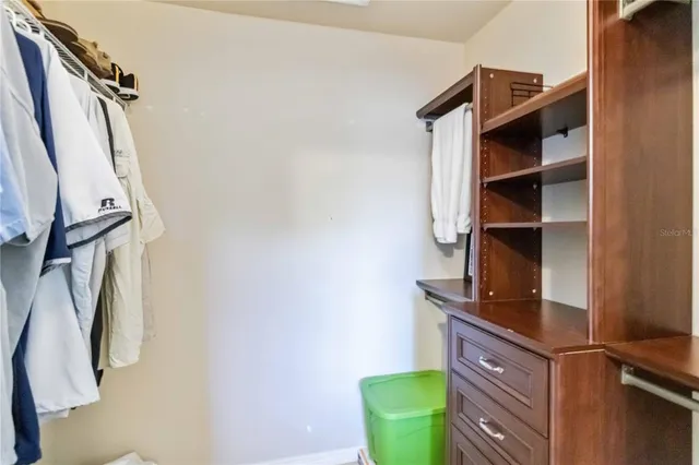 a view of walk in closet with clothes and shoes