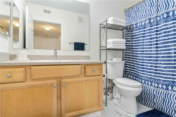 a bathroom with a granite countertop toilet sink and mirror