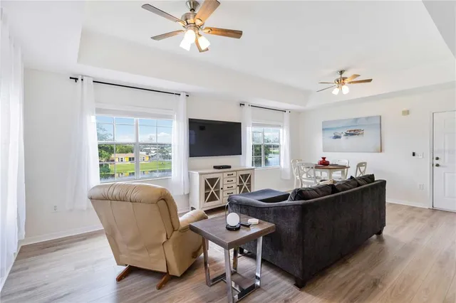 a living room with furniture a flat screen tv and a window