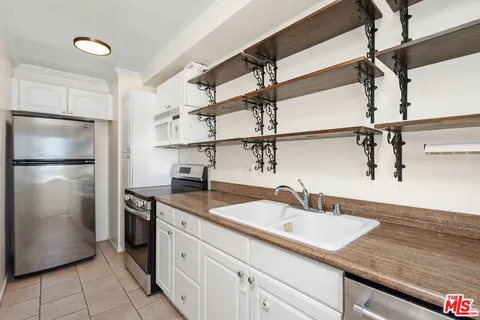 a kitchen with stainless steel appliances granite countertop a sink and a refrigerator