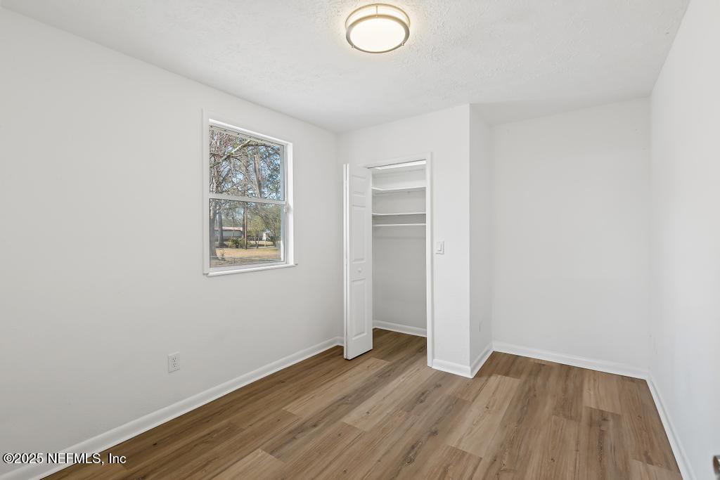 54074 Charles Street Callahan, FL 32011 - Photo 16 of 52 an empty room with wooden floor and windows