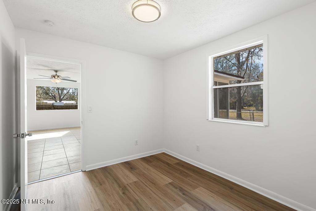 54074 Charles Street Callahan, FL 32011 - Photo 17 of 52 a view of an empty room with wooden floor and a window