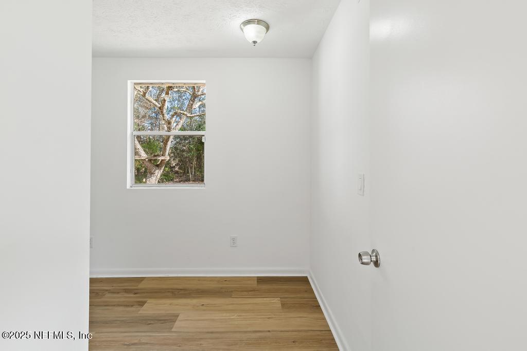 54074 Charles Street Callahan, FL 32011 - Photo 24 of 52 a view of an empty room with wooden floor and a window