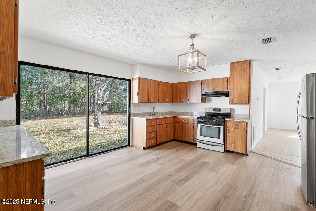 54074 Charles Street Callahan, FL 32011 - Photo 27 of 52 a large kitchen with a large window and stainless steel appliances
