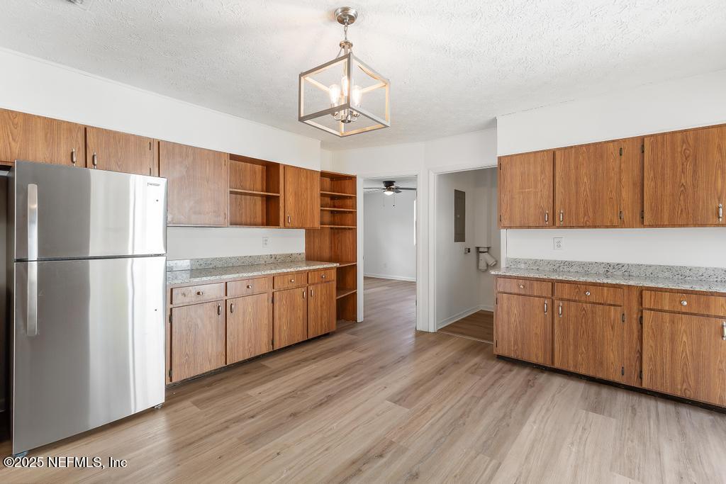 54074 Charles Street Callahan, FL 32011 - Photo 29 of 52 a kitchen with granite countertop wooden floors white cabinets and stainless steel appliances