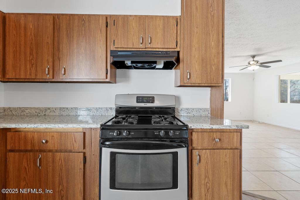 54074 Charles Street Callahan, FL 32011 - Photo 30 of 52 a kitchen with granite countertop cabinets stainless steel appliances and wooden floor