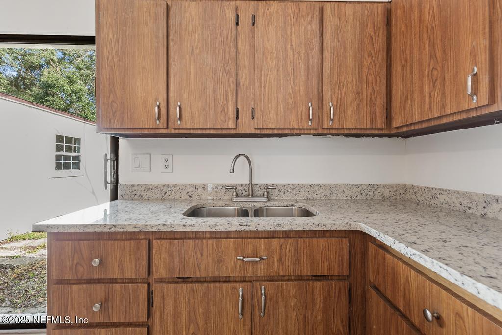54074 Charles Street Callahan, FL 32011 - Photo 31 of 52 a kitchen with a sink cabinets and a wooden floor