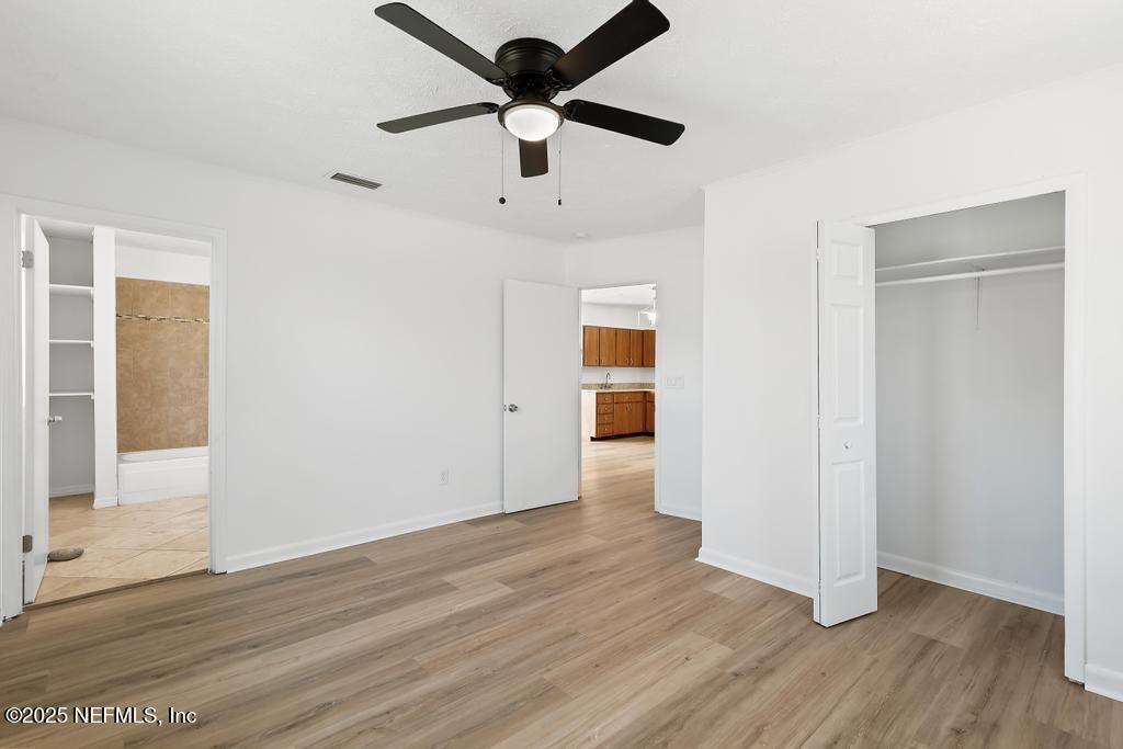 54074 Charles Street Callahan, FL 32011 - Photo 35 of 52 a view of an empty room with wooden floor and a ceiling fan