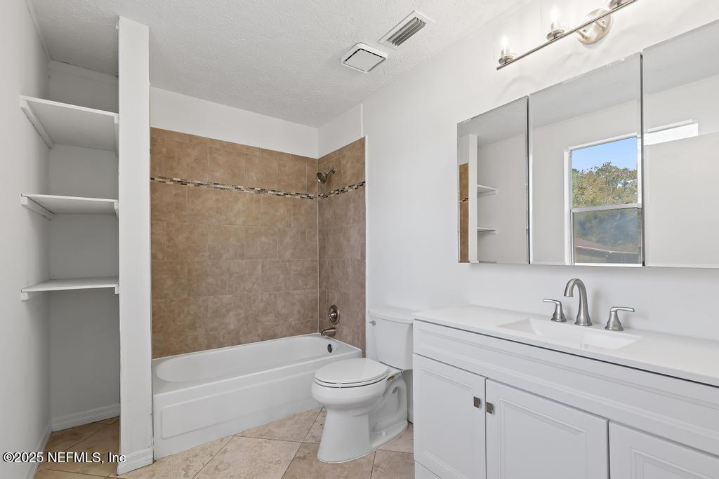 54074 Charles Street Callahan, FL 32011 - Photo 37 of 52 a bathroom with a toilet a sink a mirror a bathtub and vanity