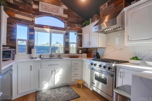 a kitchen with stainless steel appliances granite countertop a stove and a white cabinets