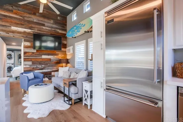 a bedroom with bed and a washing machine with the side of it