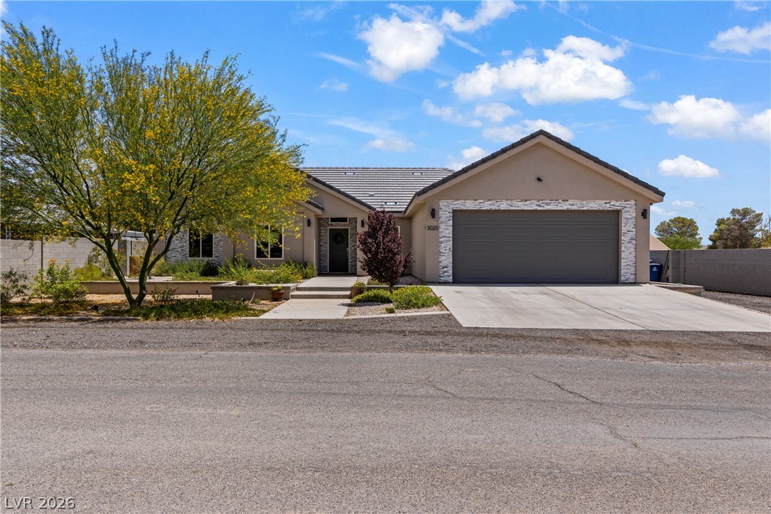 A desert-friendly landscape surrounds this single-story home with a two-car garage.
