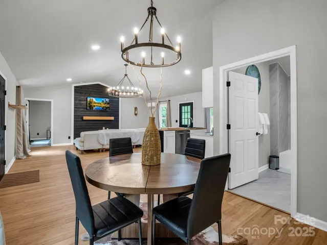 a view of a dining room with furniture a chandelier and wooden floor