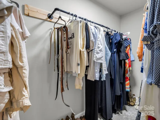 a view of walk in closet with clothes