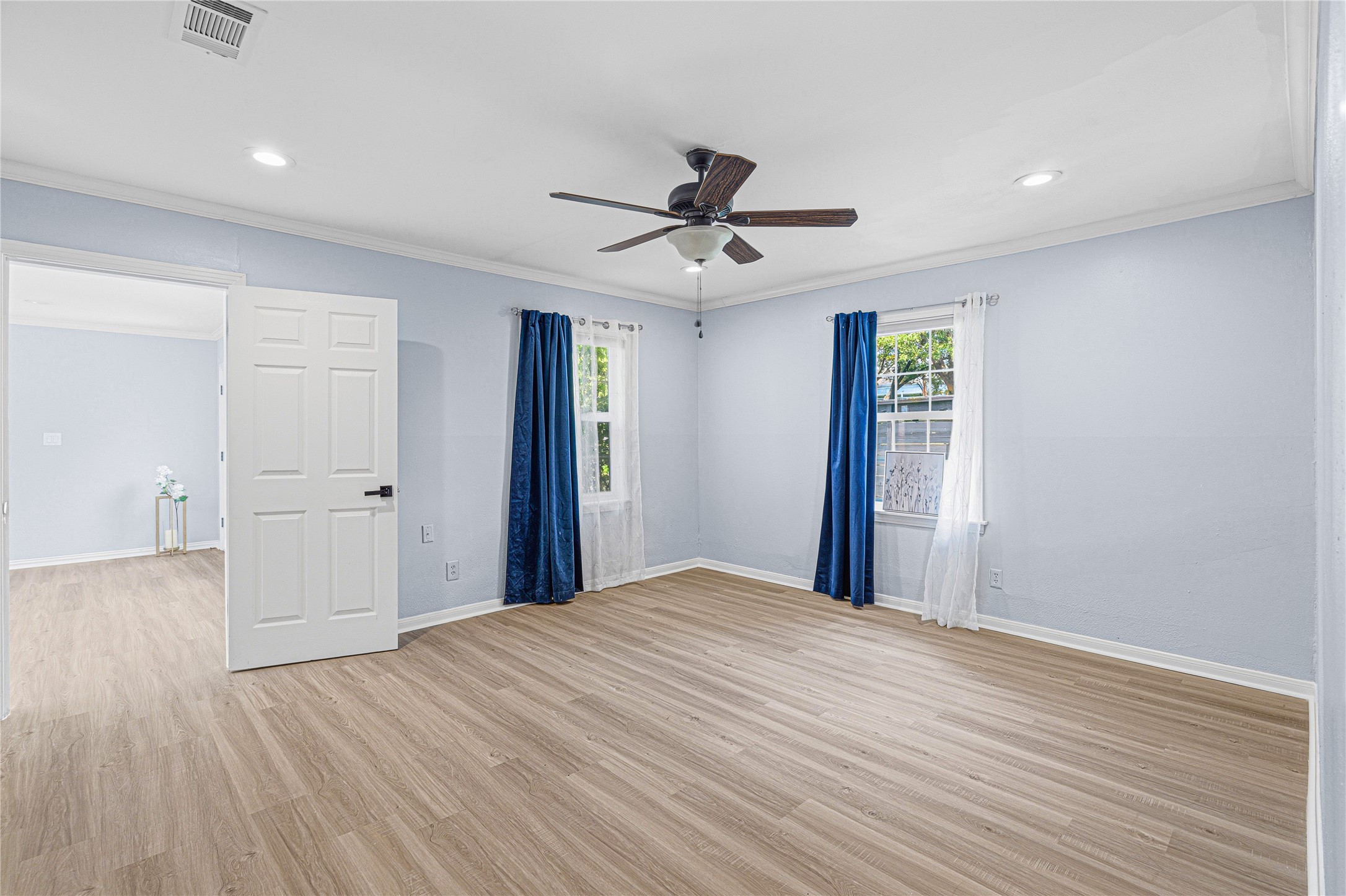 4002 Merrick Street Houston, TX 77025 - Photo 11 of 22 a view of an empty room with wooden floor and a ceiling fan