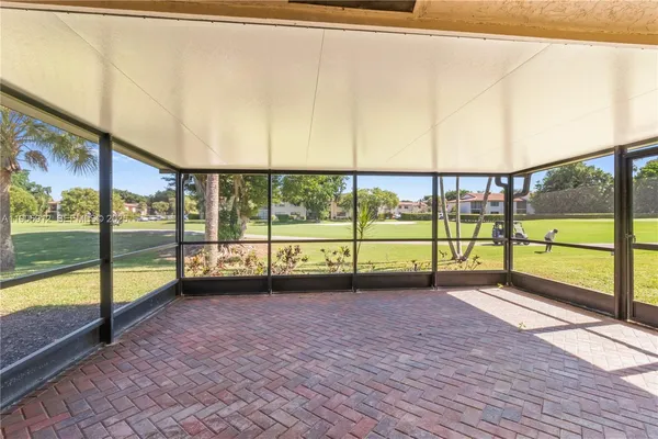 a view of an empty room with a floor to ceiling window next to a yard