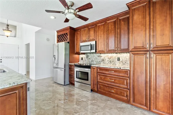 a kitchen with granite countertop wooden cabinets and stainless steel appliances