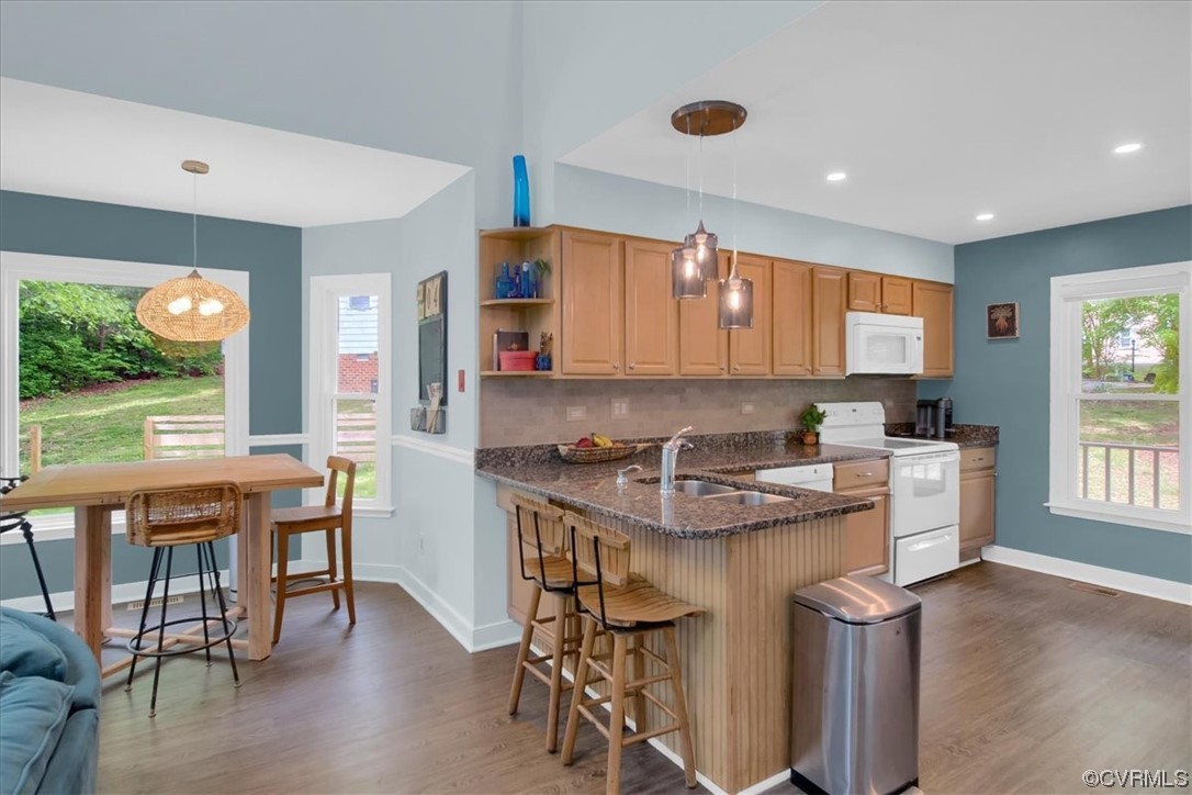 7121 Pointer Ridge Road Midlothian, VA 23112 - Photo 17 of 50 a kitchen with stainless steel appliances granite countertop a stove top oven a refrigerator a dining table and chairs with wooden floor