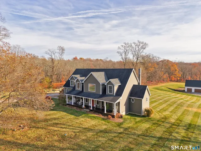 a view of a house with a big yard and large trees