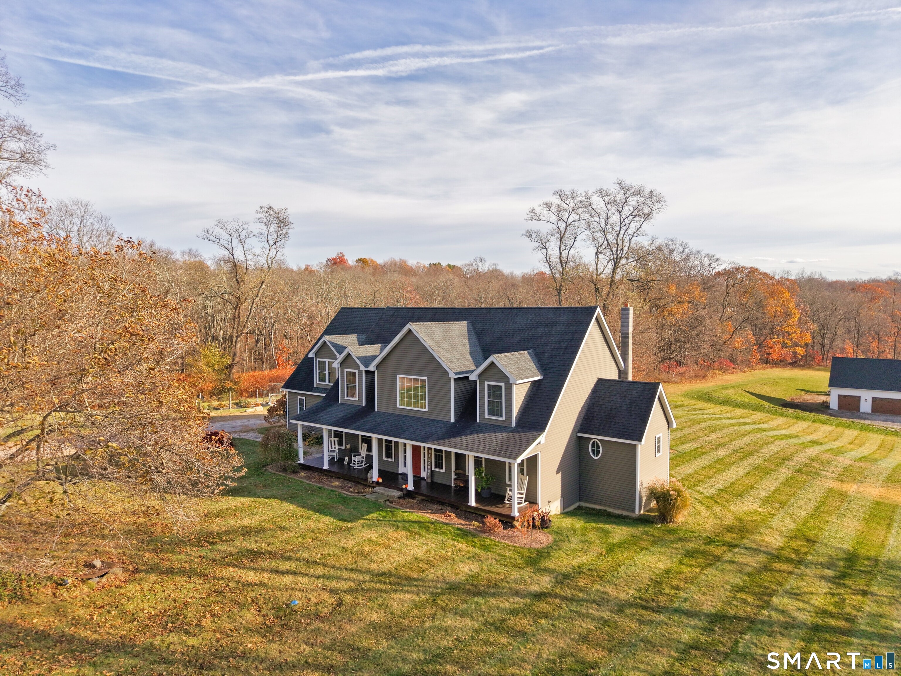 a view of a house with a big yard and large trees