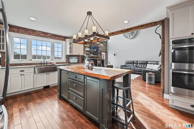 a kitchen with stainless steel appliances granite countertop a sink a stove and a refrigerator