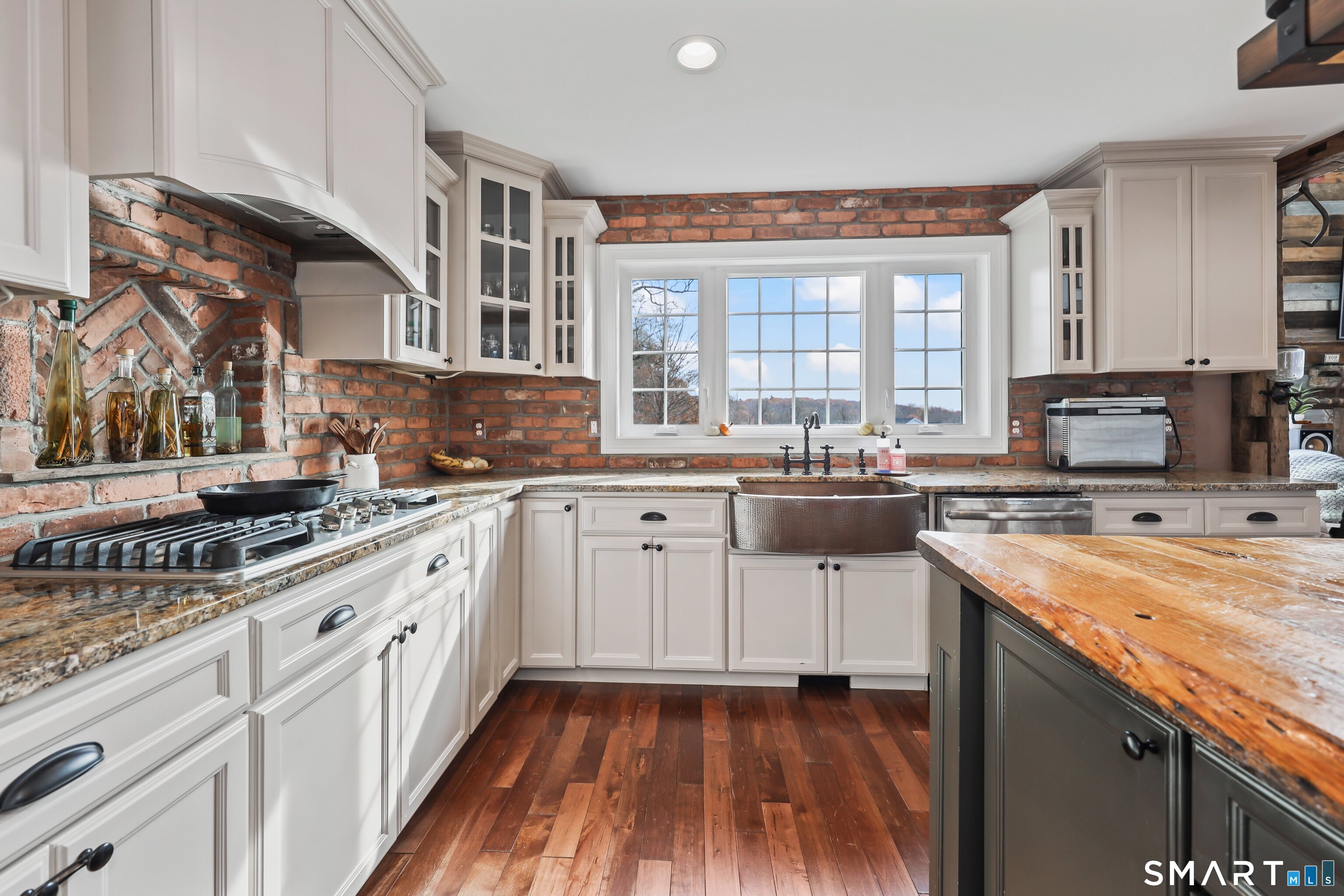 195 Hinman Road Watertown, CT 06795 - Photo 15 of 39 a kitchen with stainless steel appliances granite countertop a stove a sink dishwasher and white cabinets with wooden floor
