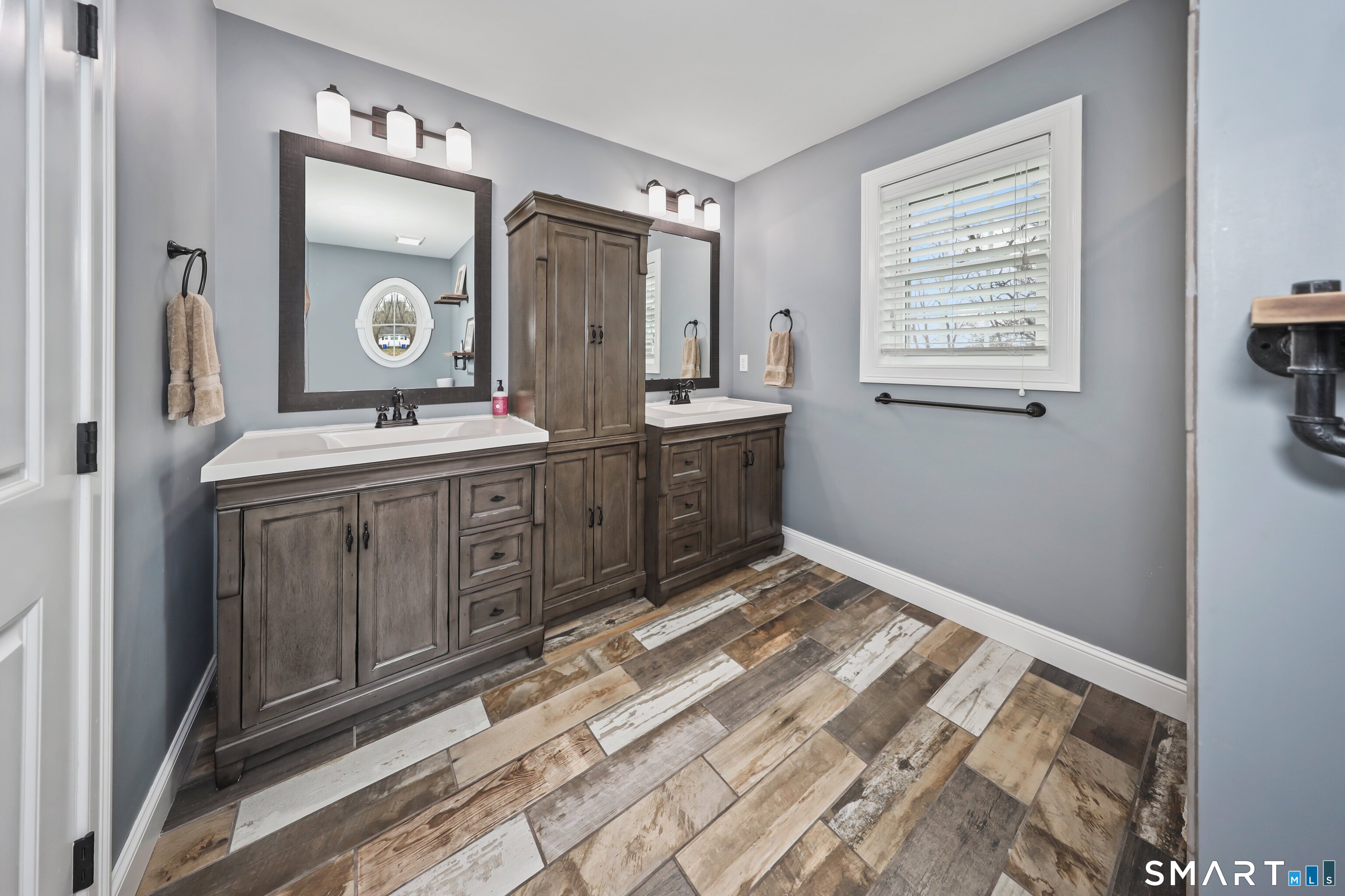 195 Hinman Road Watertown, CT 06795 - Photo 22 of 39 a spacious bathroom with a mirror a sink and a window