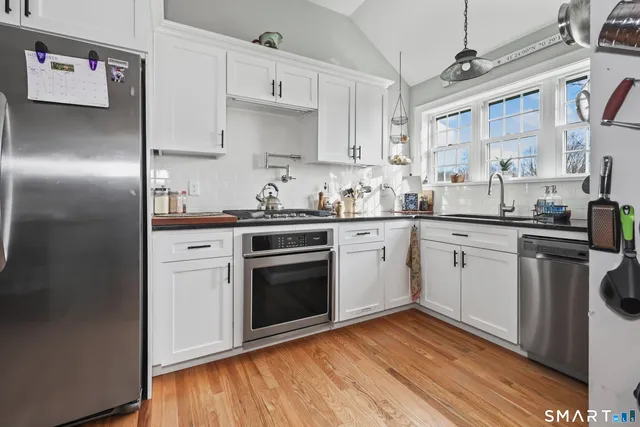 a kitchen with a sink cabinets stainless steel appliances and a window