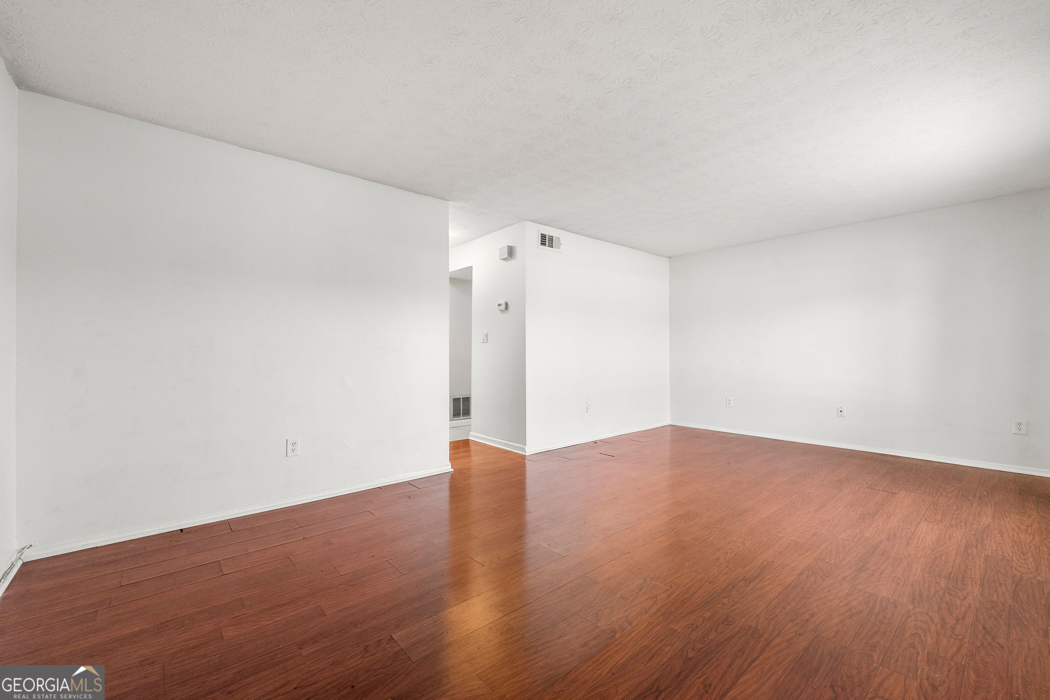 1820 Ashborough Road Southeast, Unit B Marietta, GA 30067 - Photo 4 of 21 an empty room with wooden floor and windows
