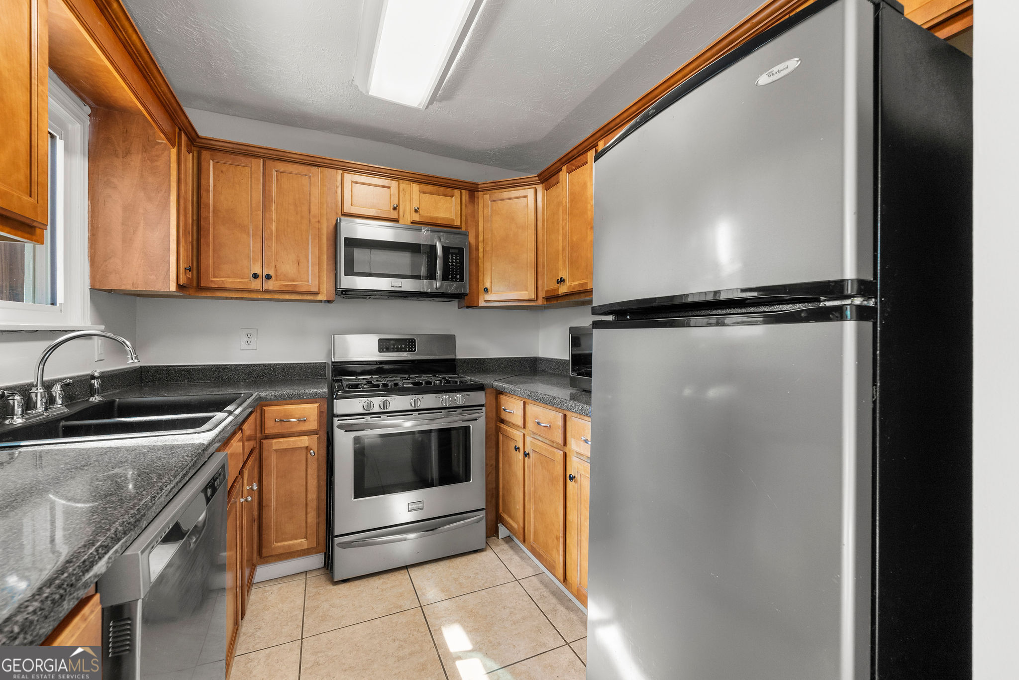 1820 Ashborough Road Southeast, Unit B Marietta, GA 30067 - Photo 10 of 21 a kitchen with stainless steel appliances granite countertop a refrigerator a sink and a stove