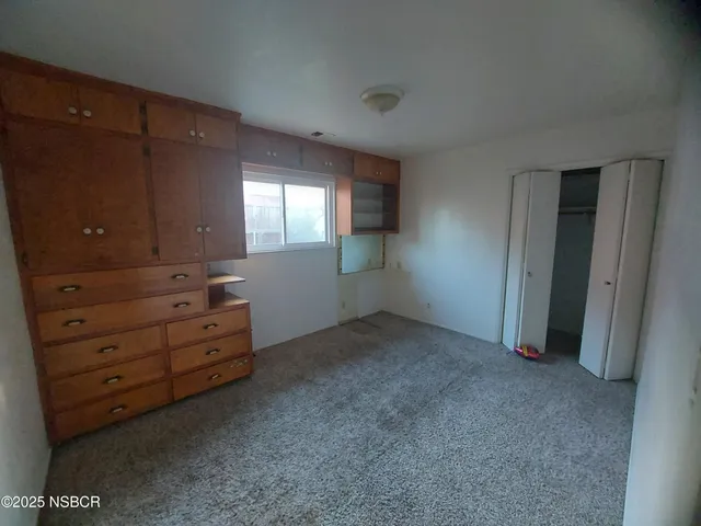 an empty room with windows and closet